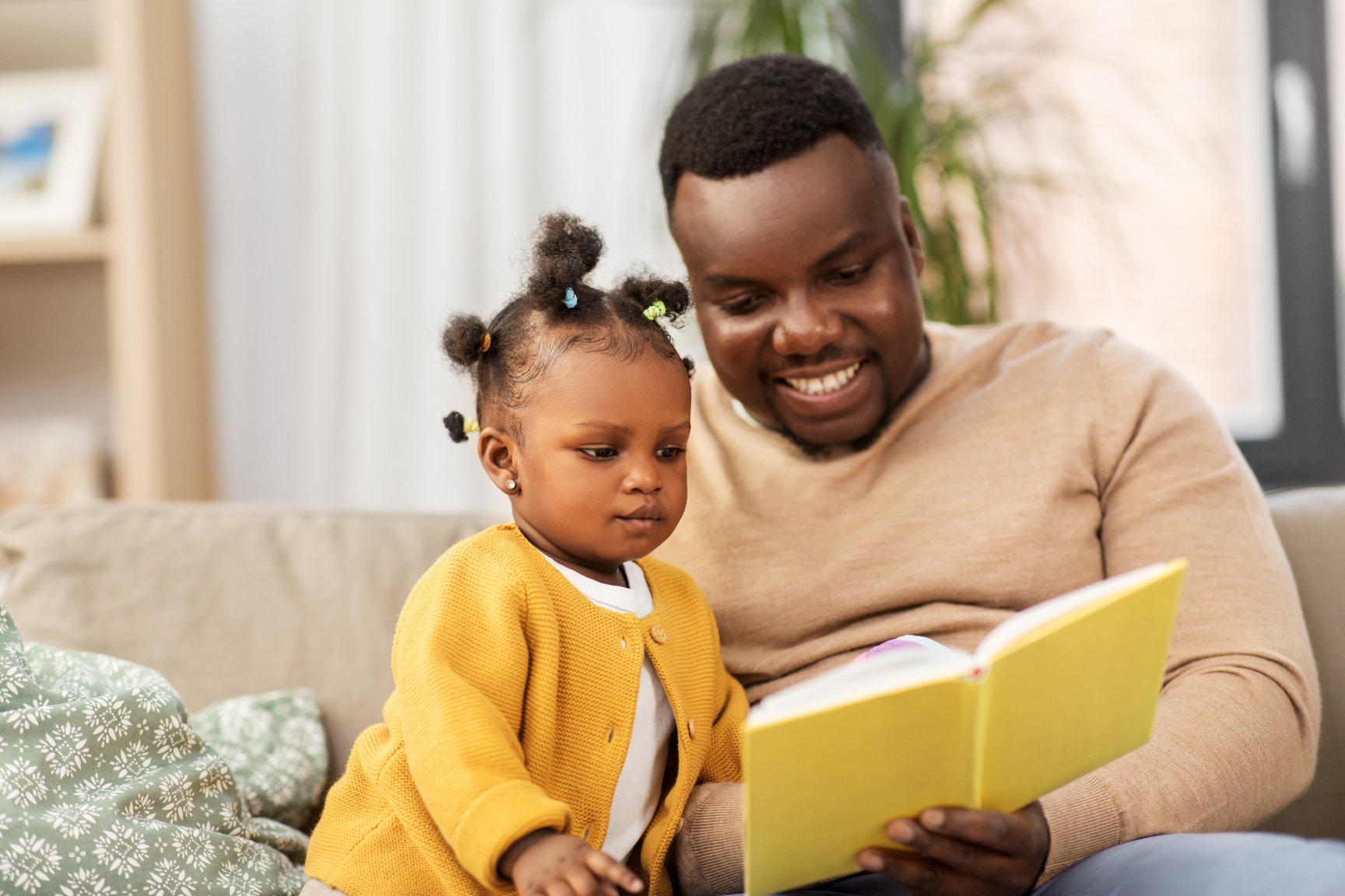 Father Reading Book for Baby Daughter